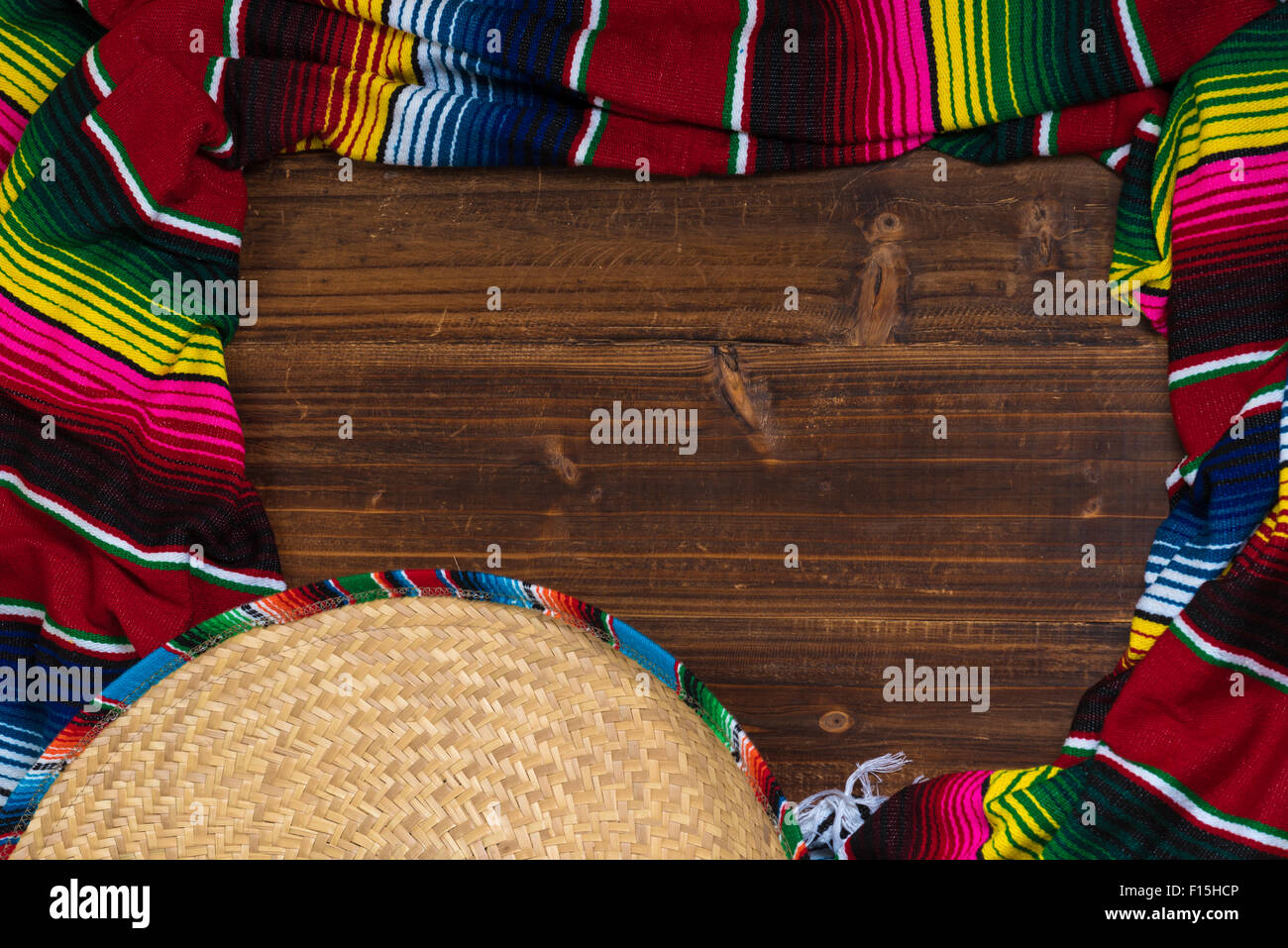 A traditional Mexican Sombrero and serape blanket on a wooden background with copy space Stock Photo