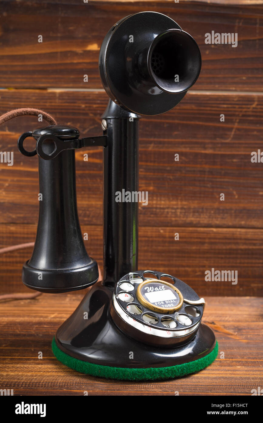 A vintage, old-fashioned, antique candlestick telephone on a wood background Stock Photo