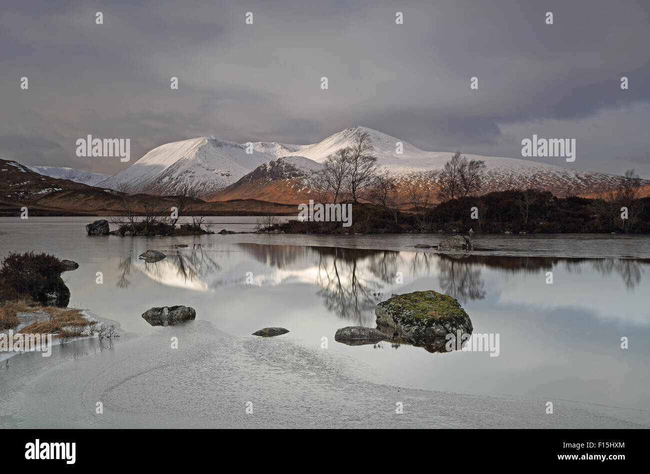 The Lovely Black Mount Snow Capped Mountain Range With A Frozen Lochan