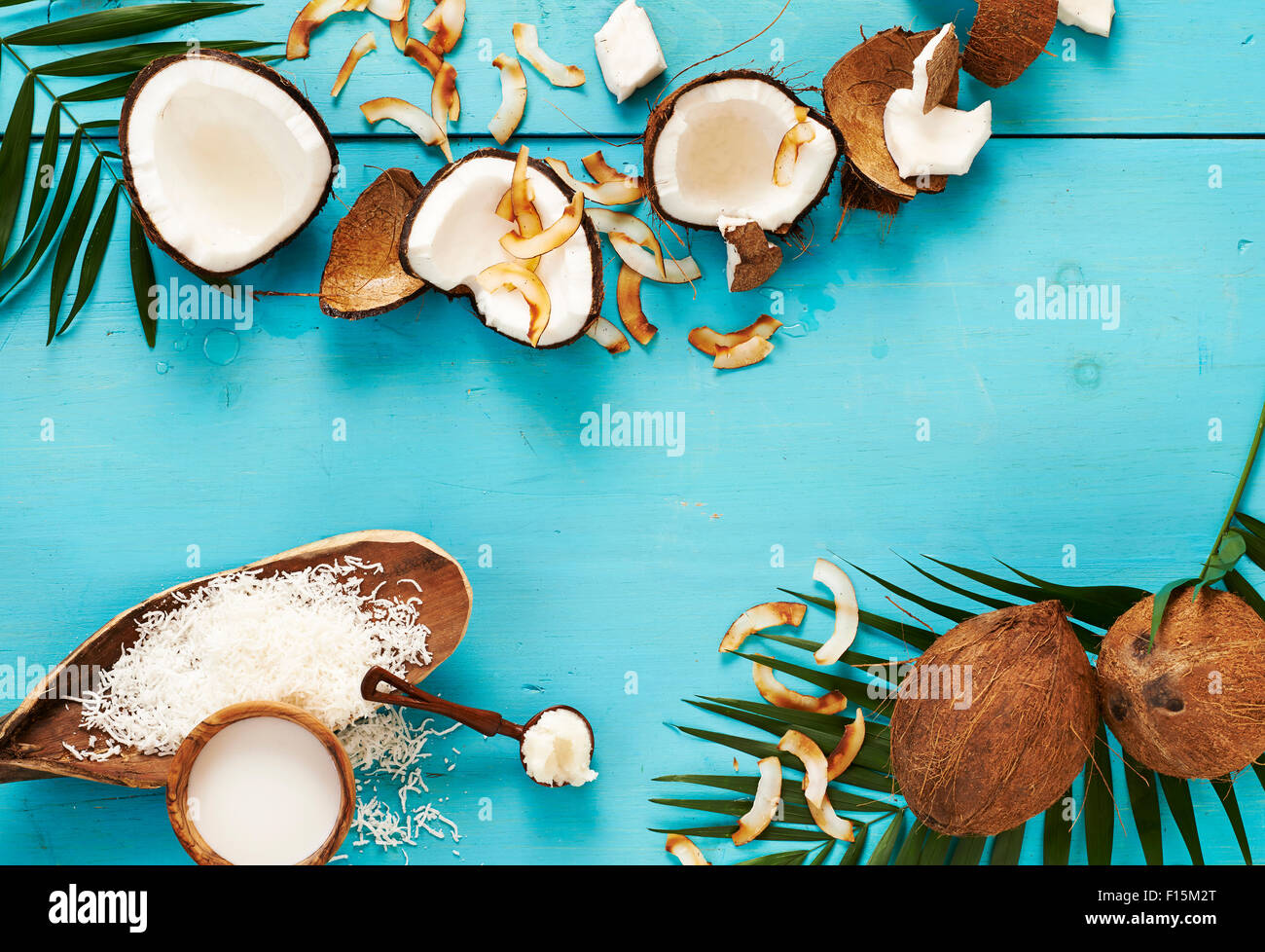 Coconut milk, whole coconuts, coconut oil, and toasted coconut, studio shot on turquoise