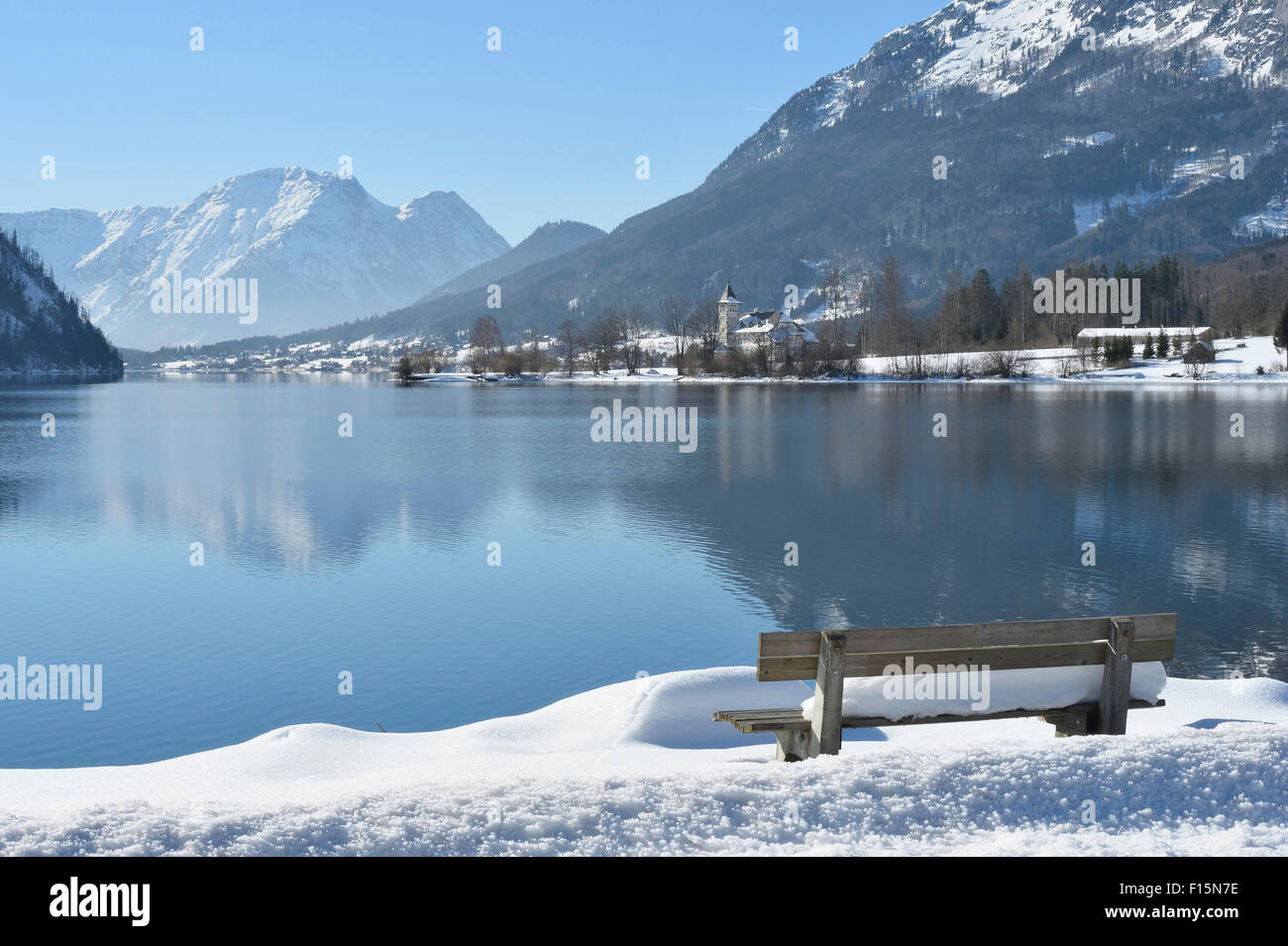 landscape-of-bench-full-of-snow-next-to-lake-grundlsee-in-winter
