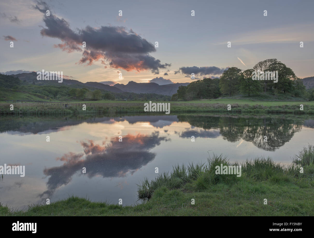 Langdale Pikes reflected in the River Brathay at dusk near Elterwater, English Lake District national park Stock Photo