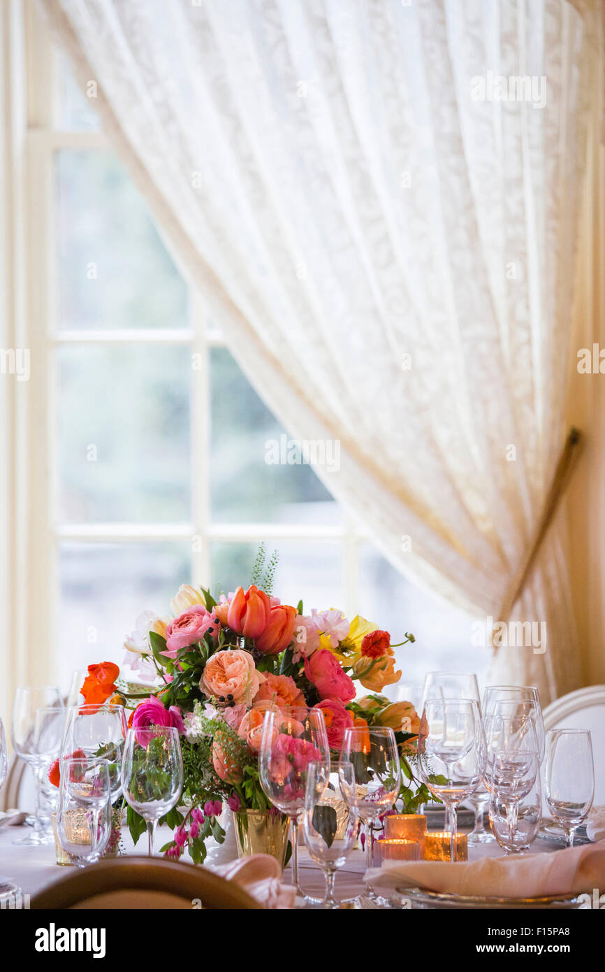 Table Setting with Floral Centerpiece by Window Stock Photo