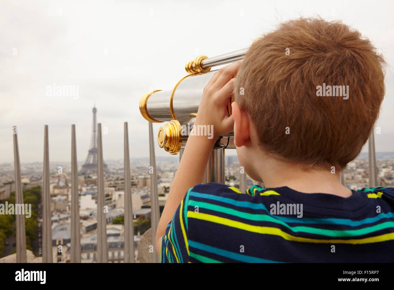 Boy Looking through Viewer over City to Eiffel Tower from Arc de Triomphe, Paris, France Stock Photo