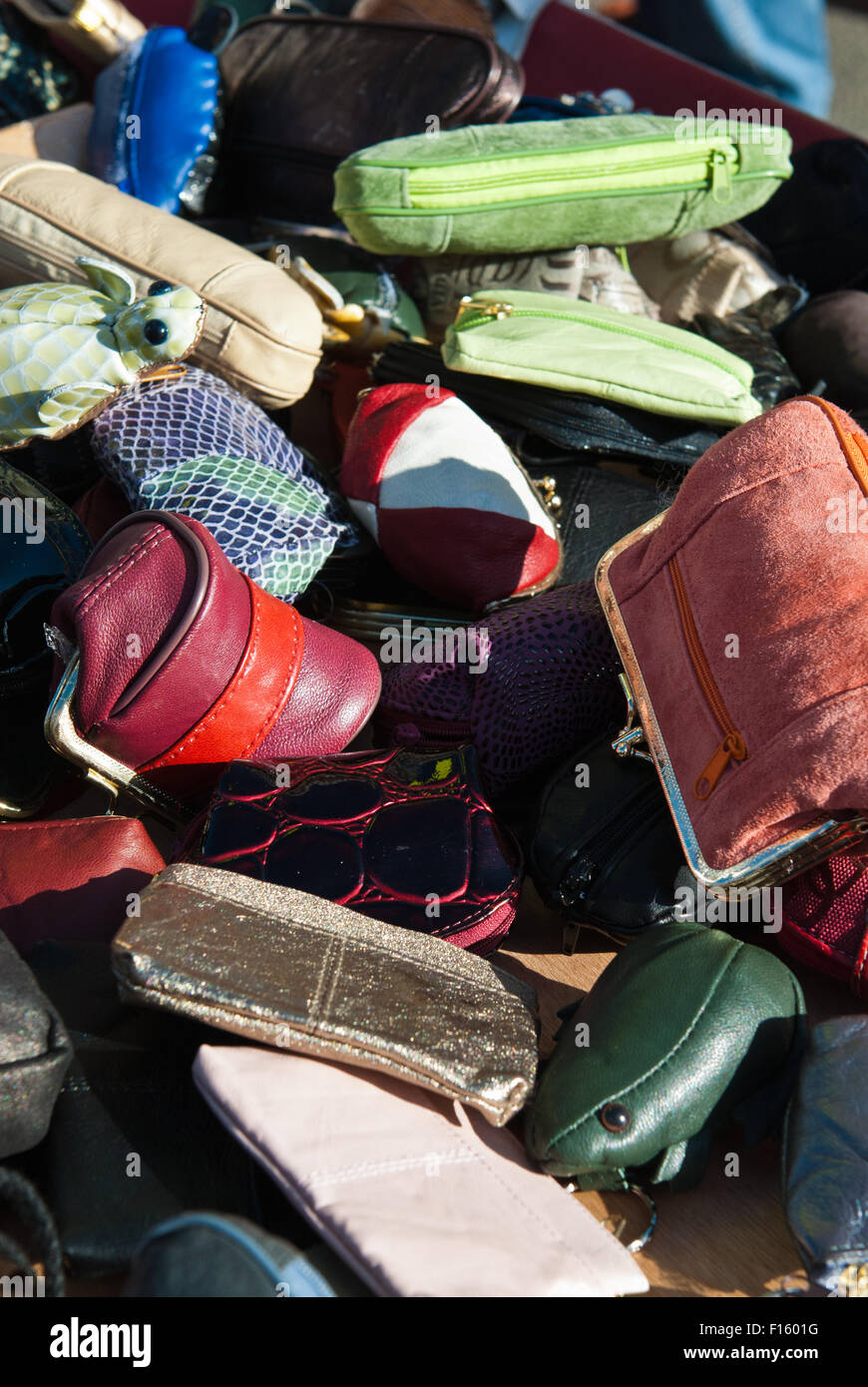 A selection of colourful leather bags displayed haphazardly for sale on a market stall Stock Photo