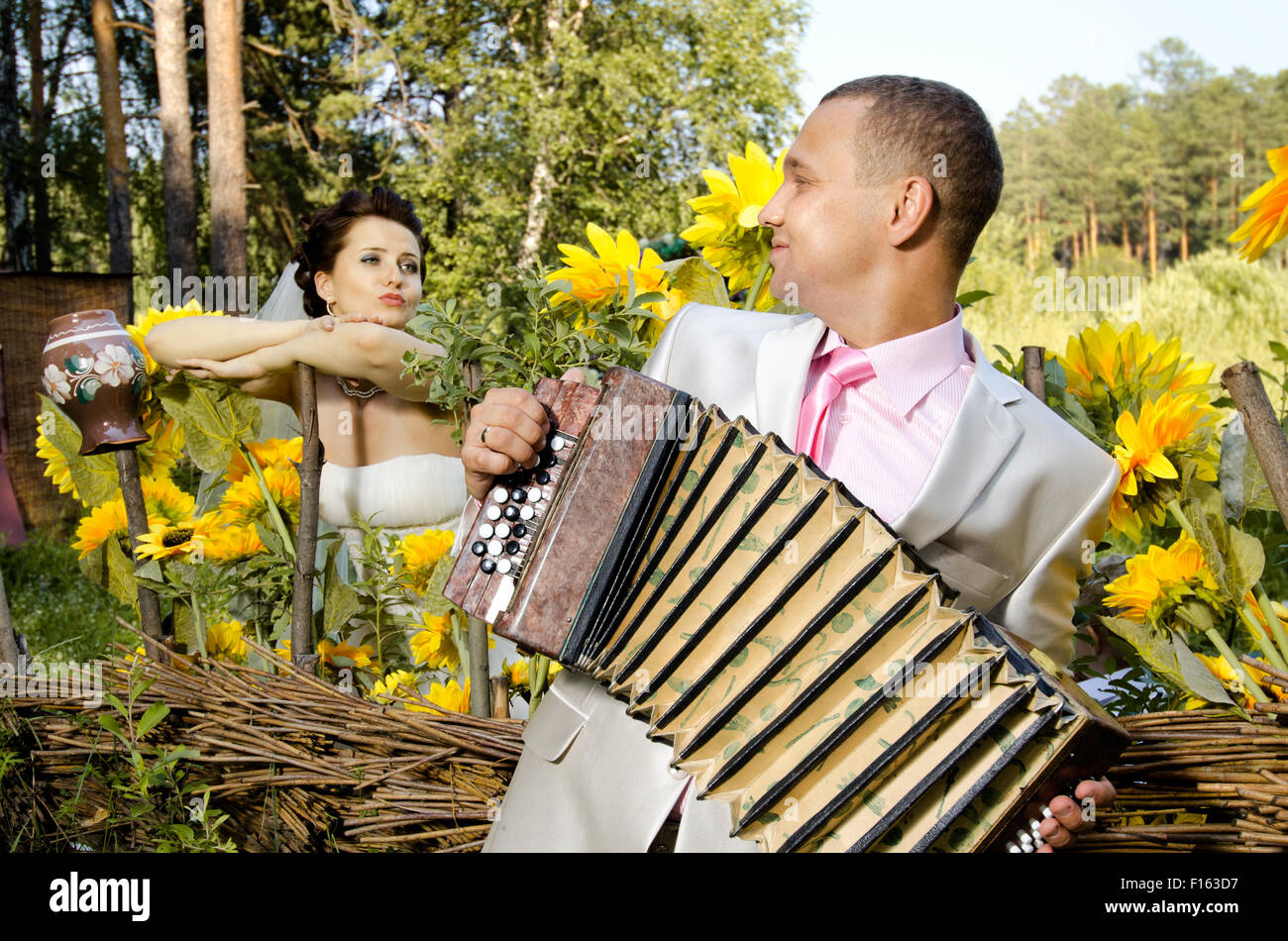 fiancee listen,  bridegroom play on accordion, wedding  humour photo Stock Photo