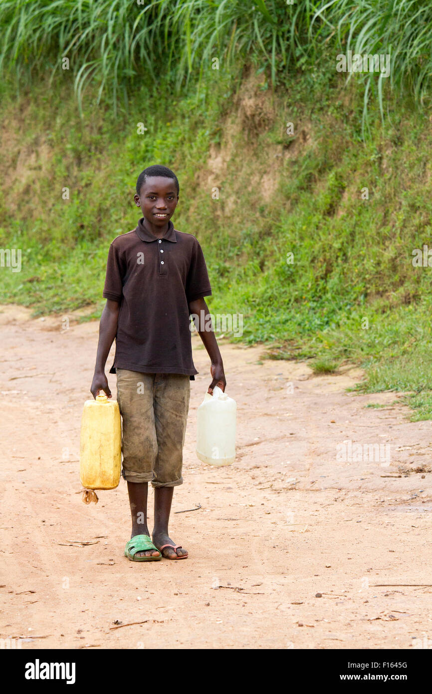 MAYANGE; RWANDA - NOVEMBER 4: Unidentified boy carries a large water jug to get water at November 4; 2013. Stock Photo