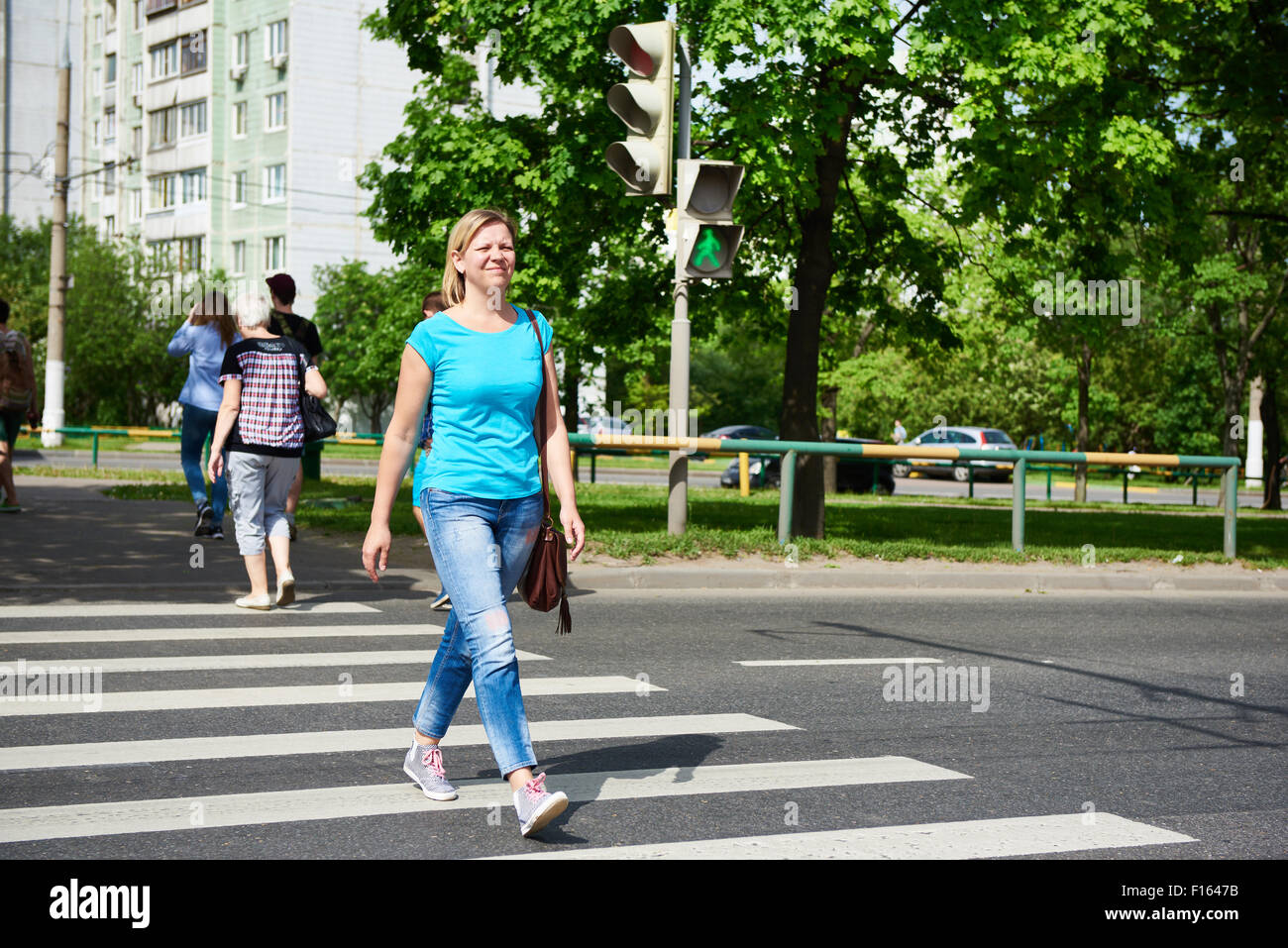 Young woman crossing the road at the green light Stock Photo - Alamy