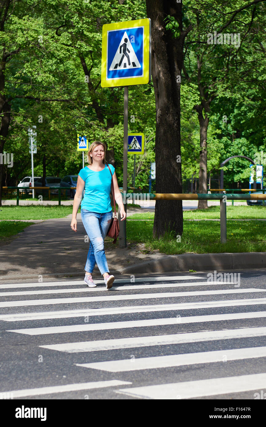 Woman crossing the street at a pedestrian crossing Stock Photo - Alamy