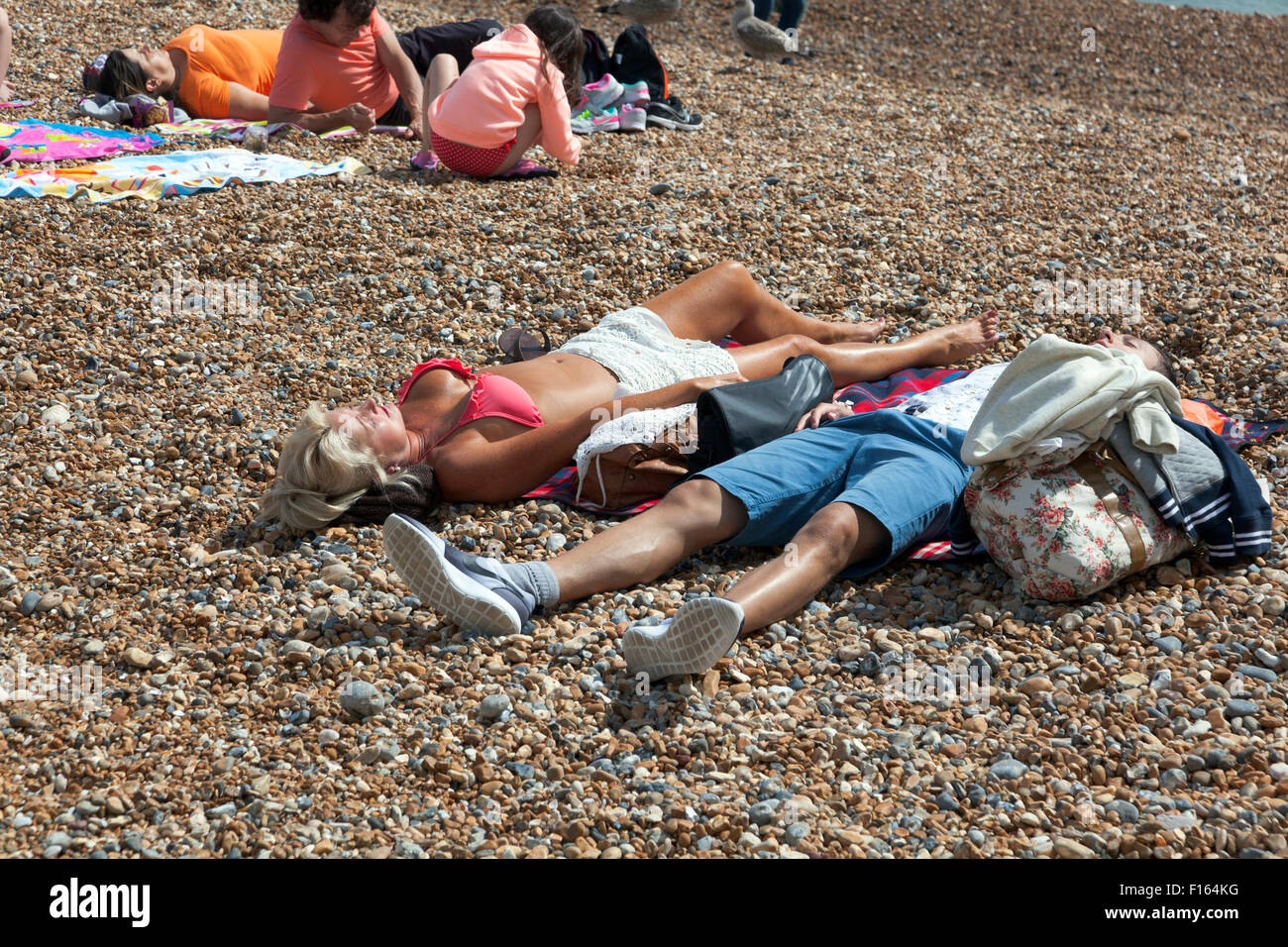 People sunbathing on the beach in Brighton, UK Stock Photo