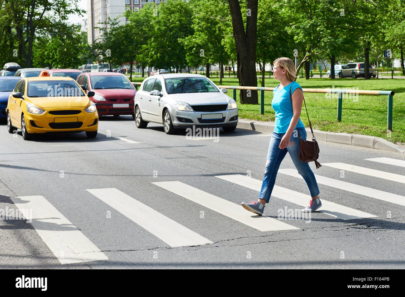 Woman crossing the street at a pedestrian crossing Stock Photo - Alamy