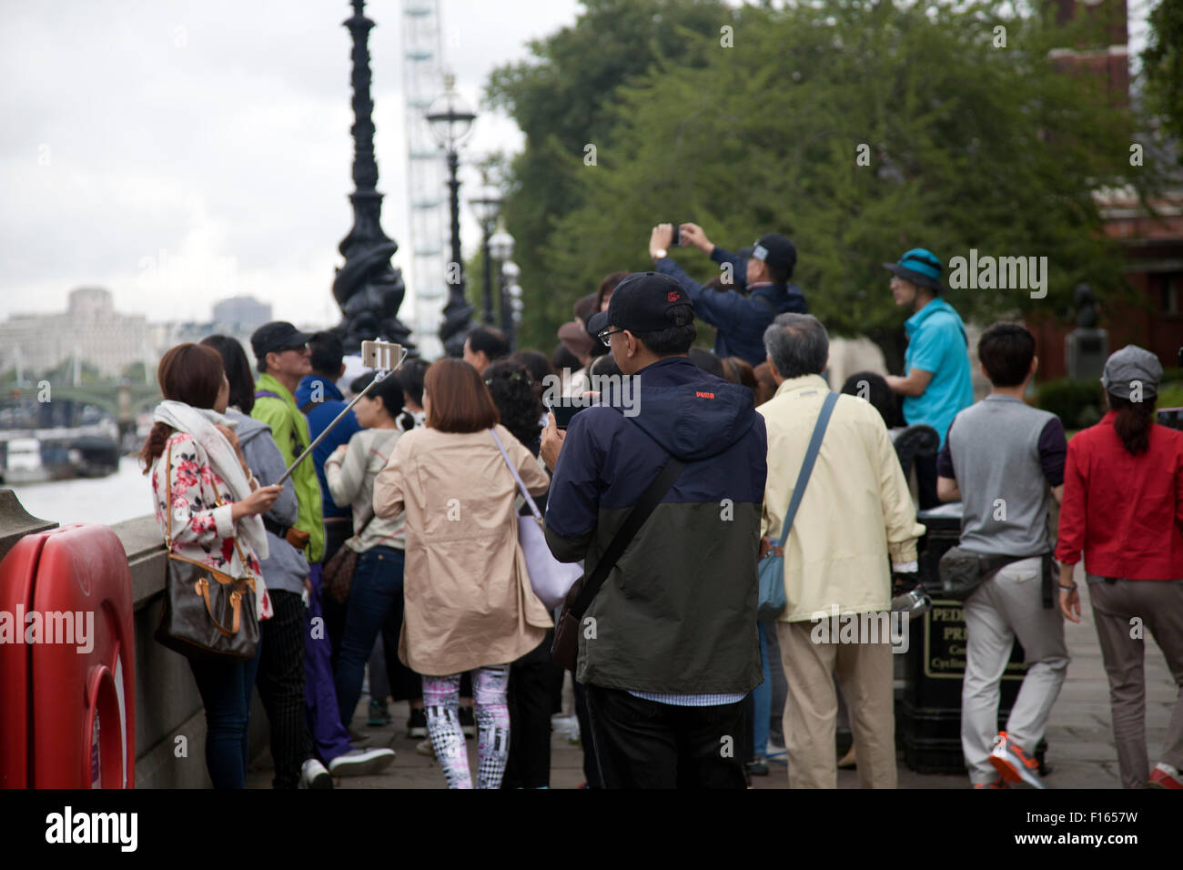 Tourists along South Bank in Westminster Taking Pictures - London UK Stock Photo