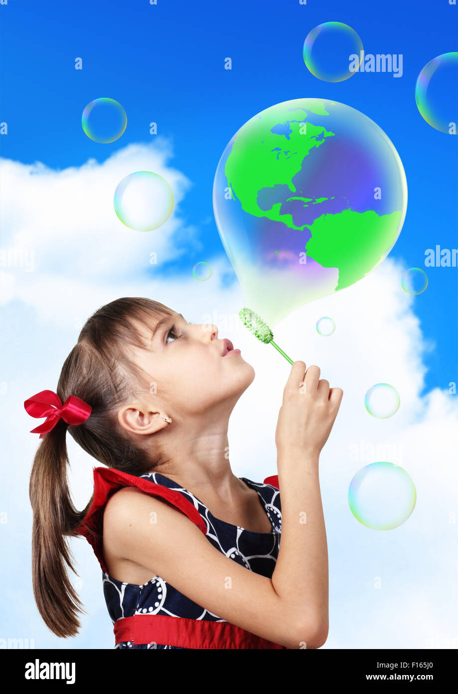 conceptual image, Child girl blowing soap bubble forming globe earth Stock Photo