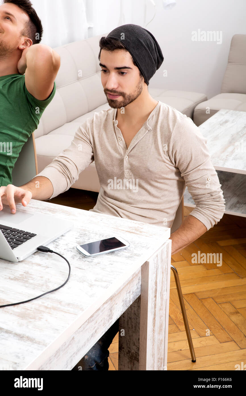 Two young men working in their home office Stock Photo - Alamy