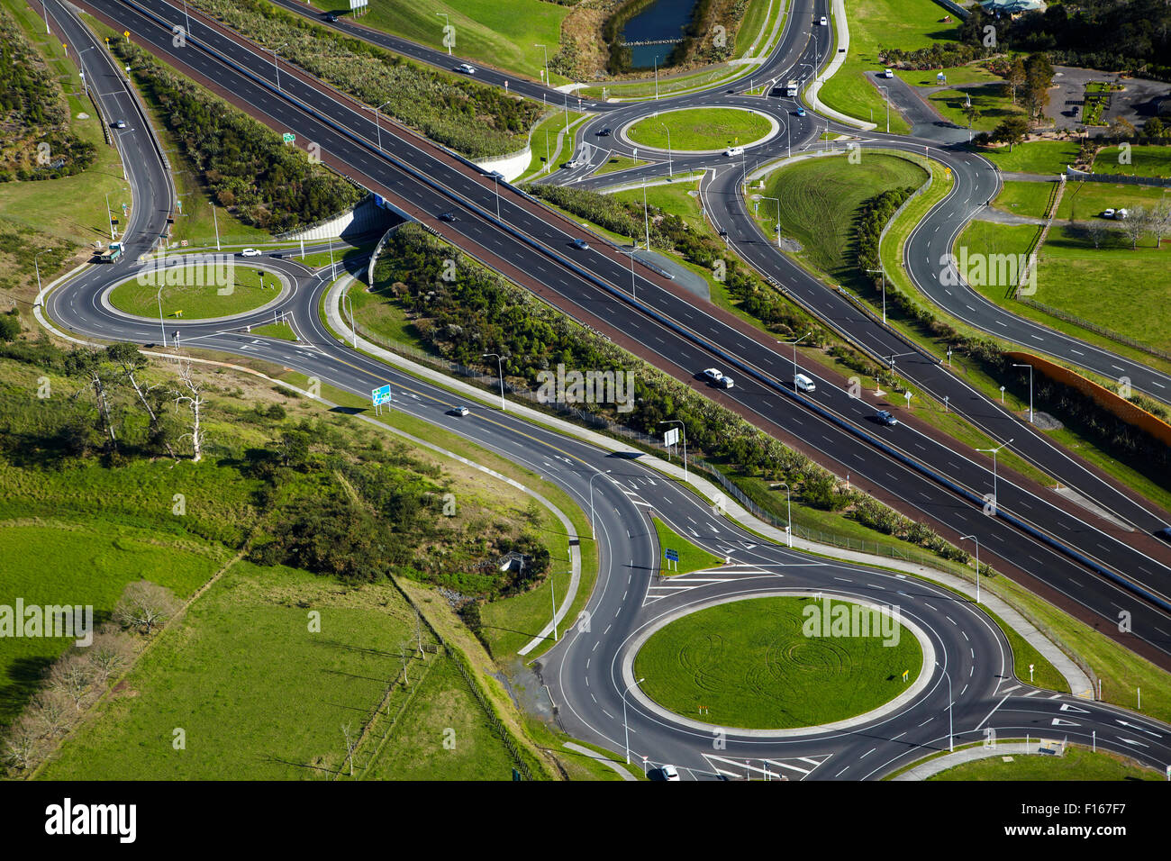 Roundabouts and Upper Harbour Motorway, Hobsonville, Auckland, North Island, New Zealand - aerial Stock Photo