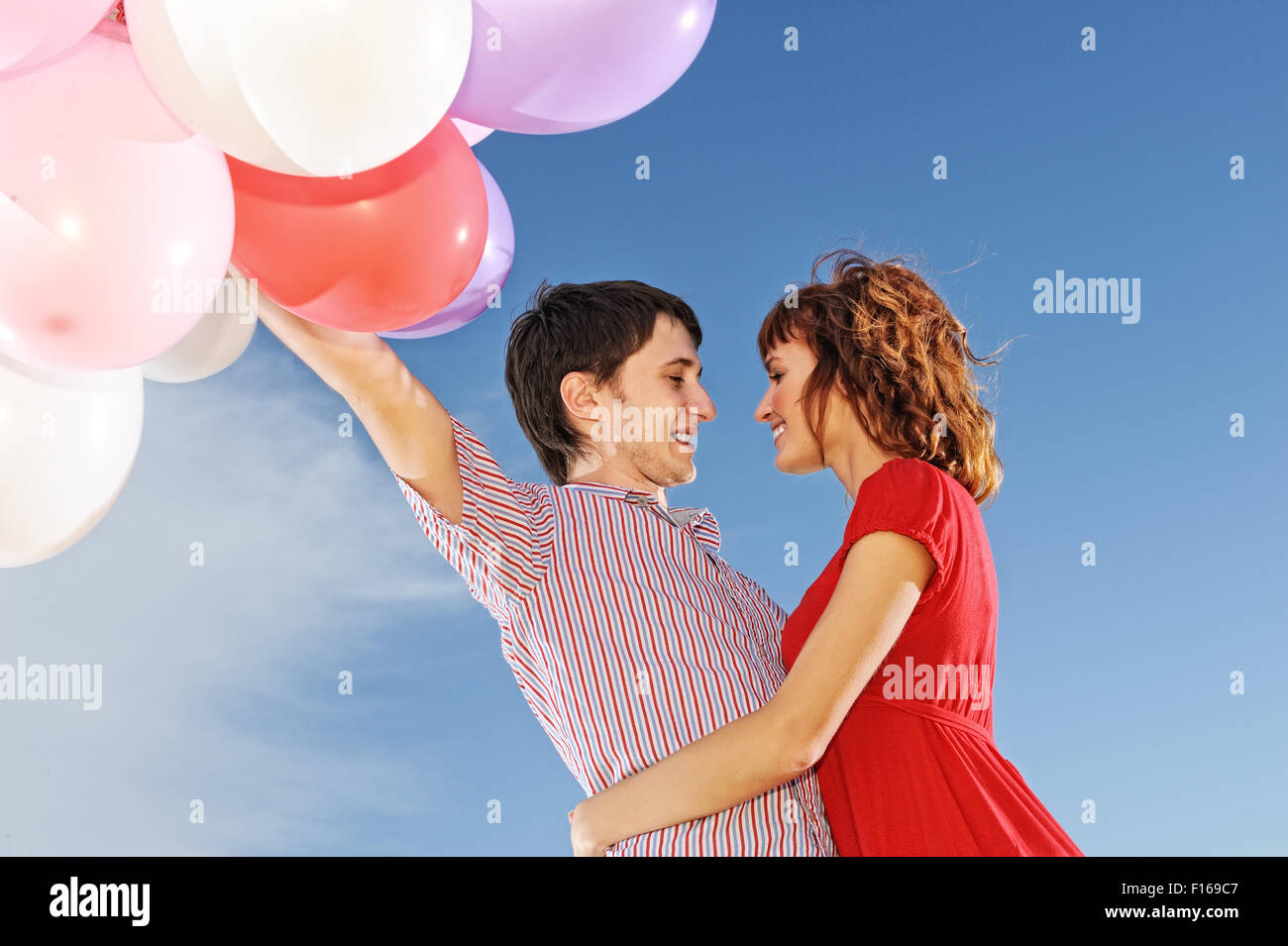 Happy couple with colorful balloons outdoors Stock Photo - Alamy