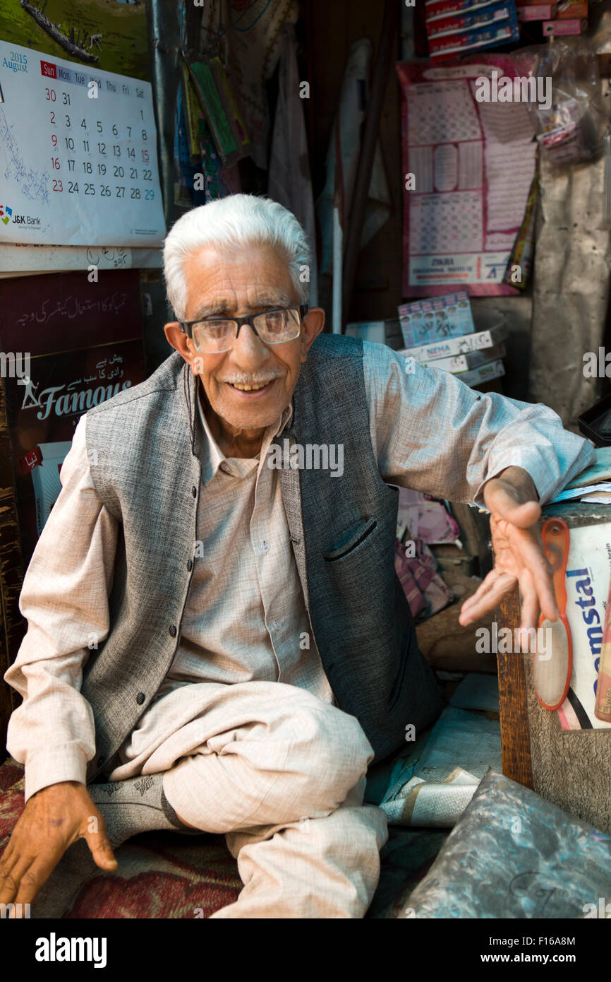 India, Jammu & Kashmir, Srinagar, old city, Sri Ranbir Gunj bazaar, smiling trader sitting in shop Stock Photo
