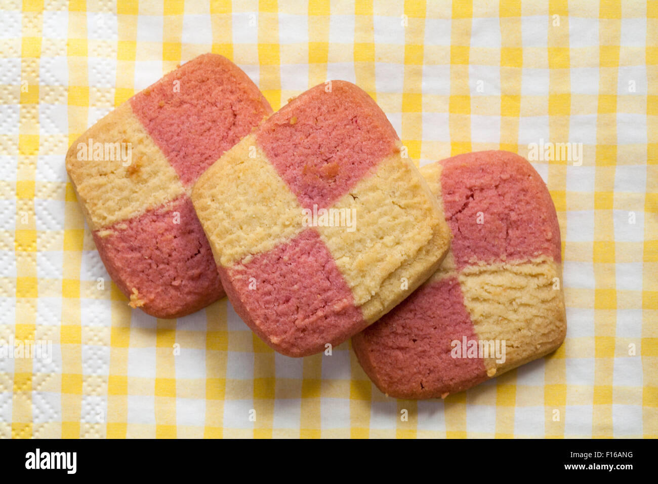 3 Marks & Spencer All Butter Battenburg Squares biscuits on yellow and white checked serviette