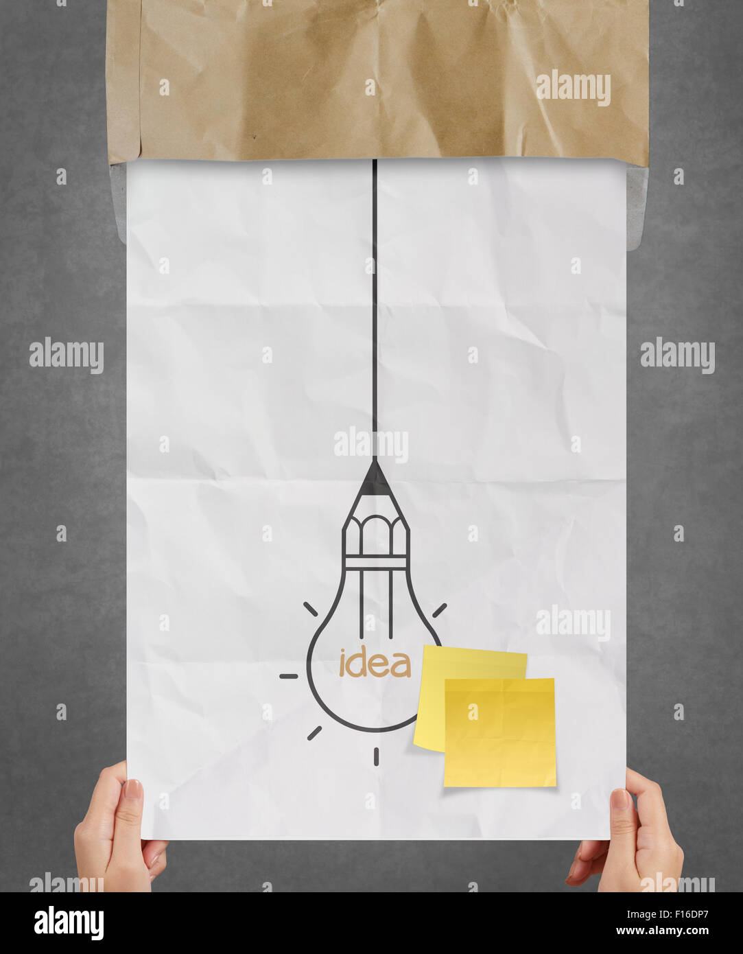 hand showing sticky note with another idea light bulb on crumpled paper ...