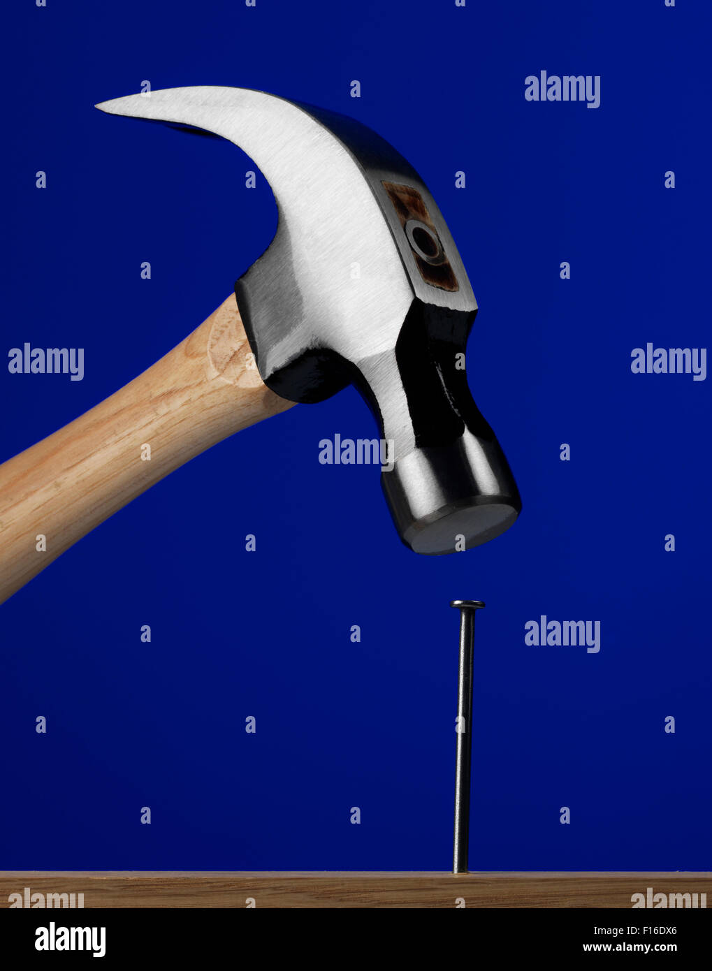 Hammer with a blue background Stock Photo - Alamy