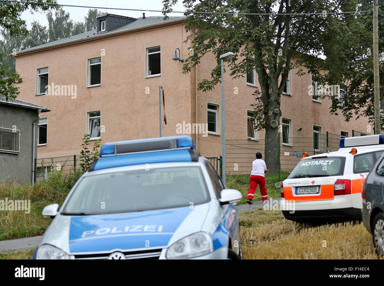 A police car and an emergency vehicle stand in front of a refugee