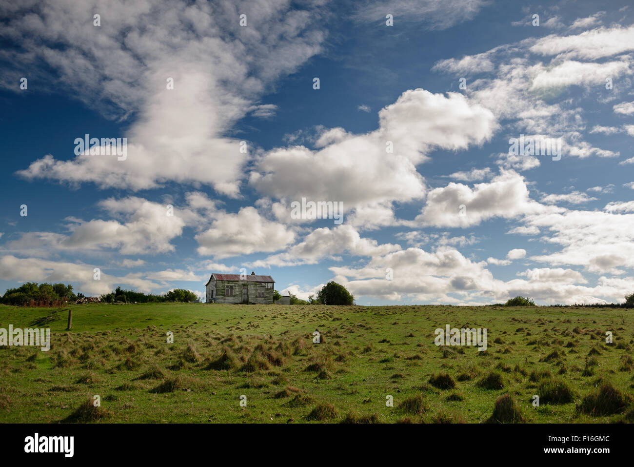 Old farm house in green field with cloudy blue sky Stock Photo - Alamy