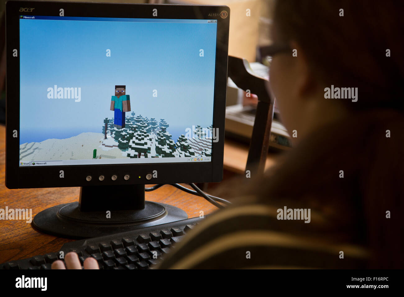 Teenage girl plays the video game Minecraft on a home computer Stock Photo