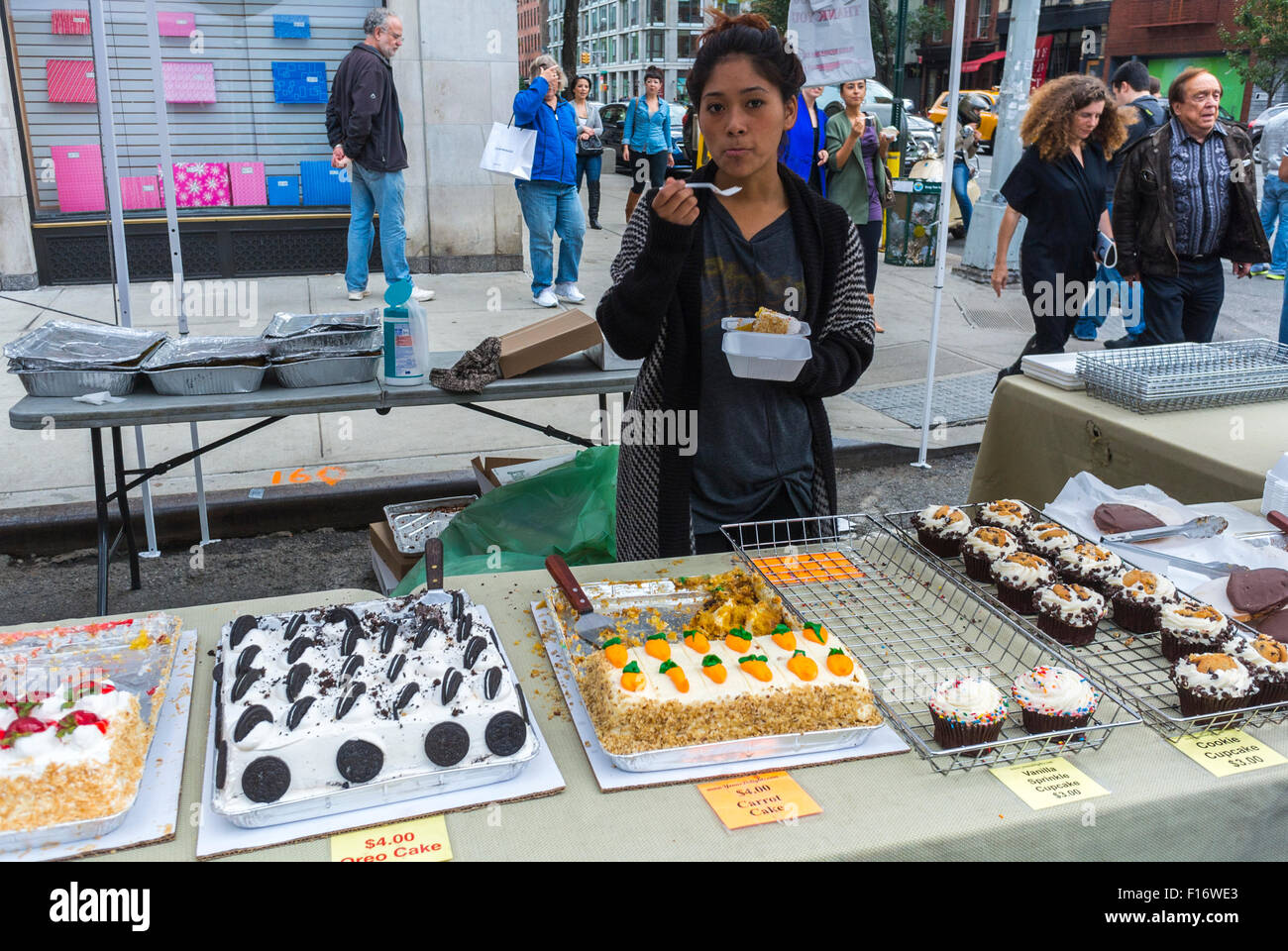 New York City, USA, Clerk city woman, Eating Cake at Food Stall, Street Food Vendor, Pastries, at outdoor Chelsea Flea Market, Summer Stock Photo