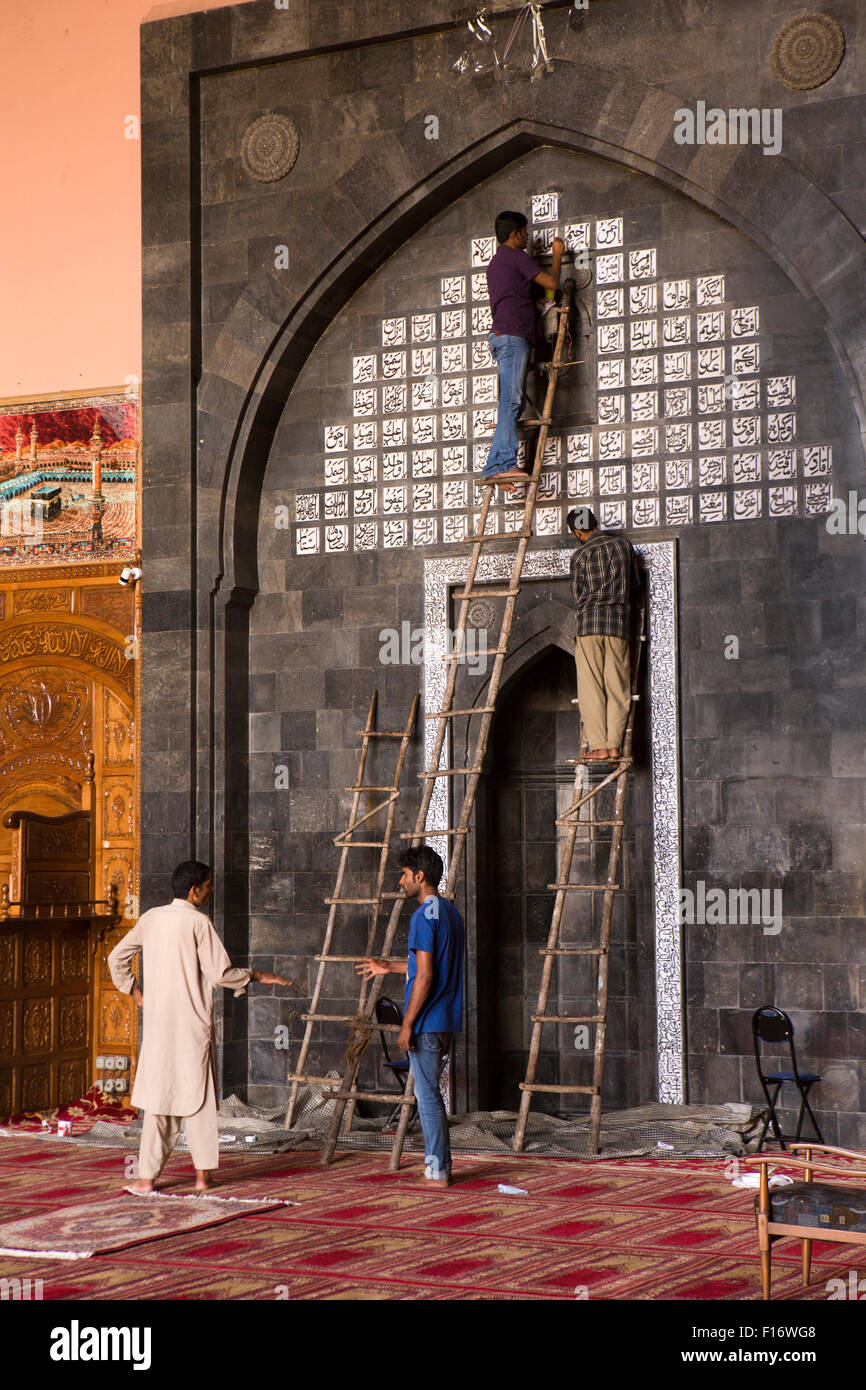 India, Jammu & Kashmir, Srinagar, Nowhatta, Jamia Masjid, interior, workmen restoring Quranic inscriptions Stock Photo