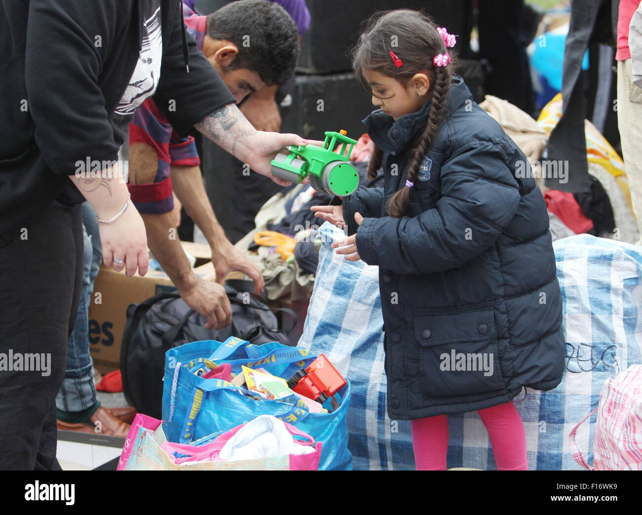 Heideau, Germany. 28th Aug, 2015. A refugee child gets a toy at a welcome party for refugees in Heideau, Germany, 28 August 2015. The welcome party was organised by Buendnis Dresden Nazifrei (lit. Dresden anti-Nazi league). PHOTO: SEBASTIAN WILLNOW/DPA/Alamy Live News Stock Photo