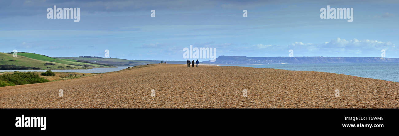 Fleet Lagoon at Abbotsbury and tourists walking on Chesil Beach tombolo, shingle structure along the Jurassic Coast, Dorset, UK Stock Photo