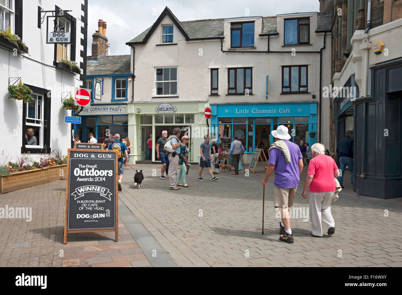 People senior couple tourists visitors walking town centre shops shop
