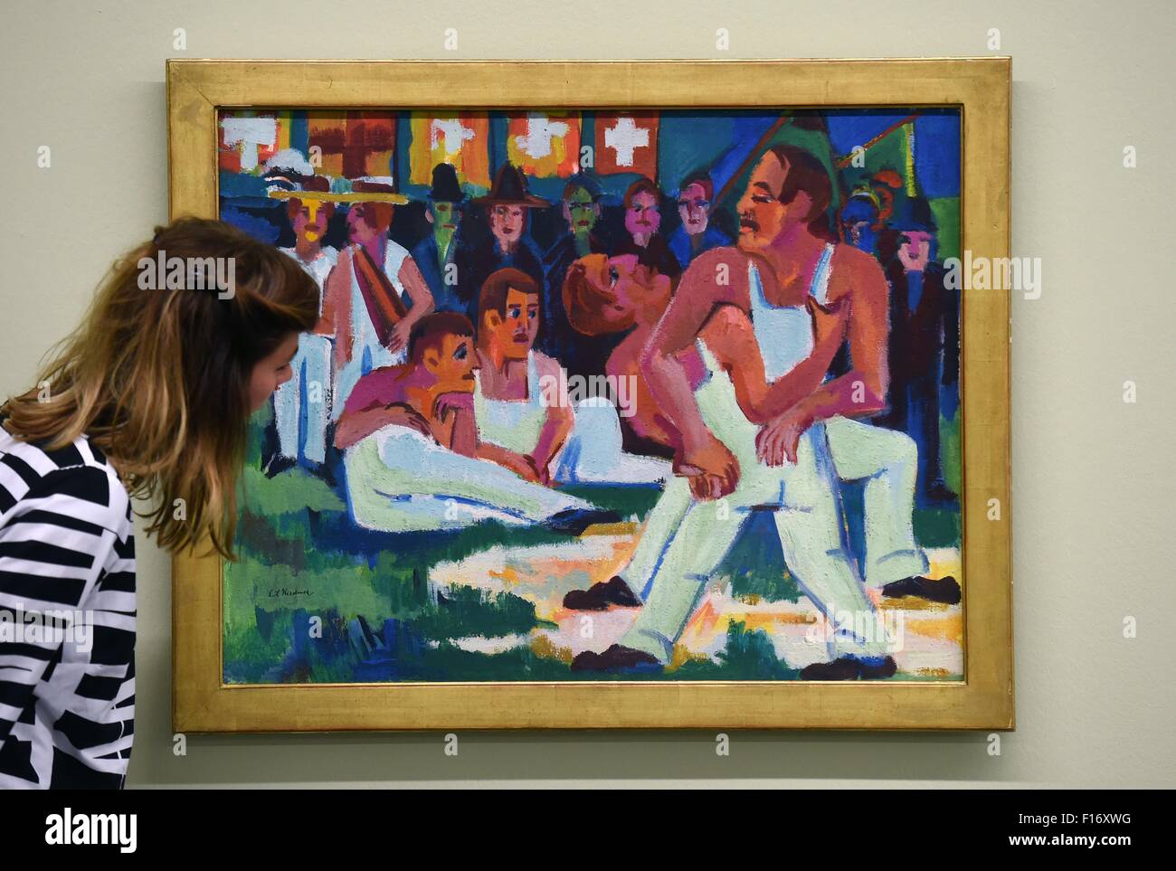 A museum employee looks at the painting 