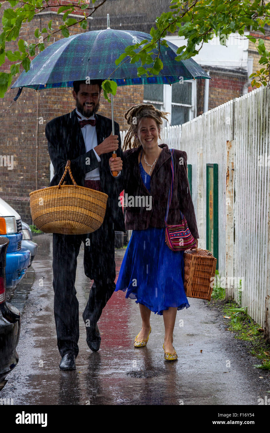 Young Opera Fans Arrive In The Pouring Rain At Lewes Station En Route To Glyndebourne Opera House, Lewes, Sussex, UK Stock Photo