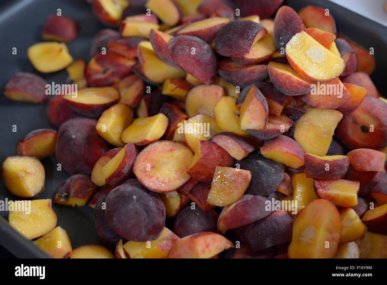 Chopped peaches in a baking tray. Stock Photo