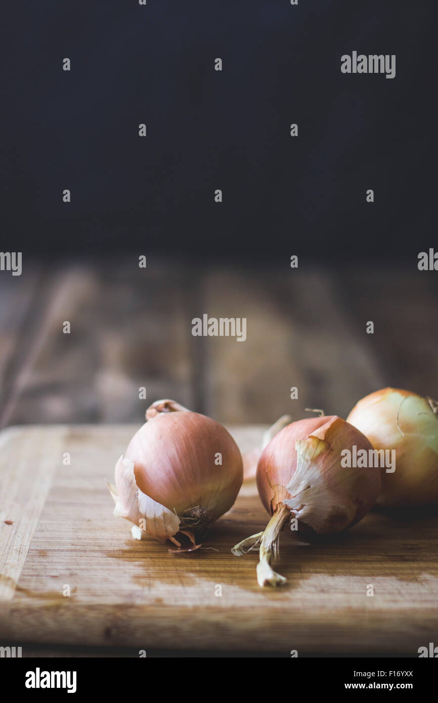 Onions on a chopping board. Stock Photo