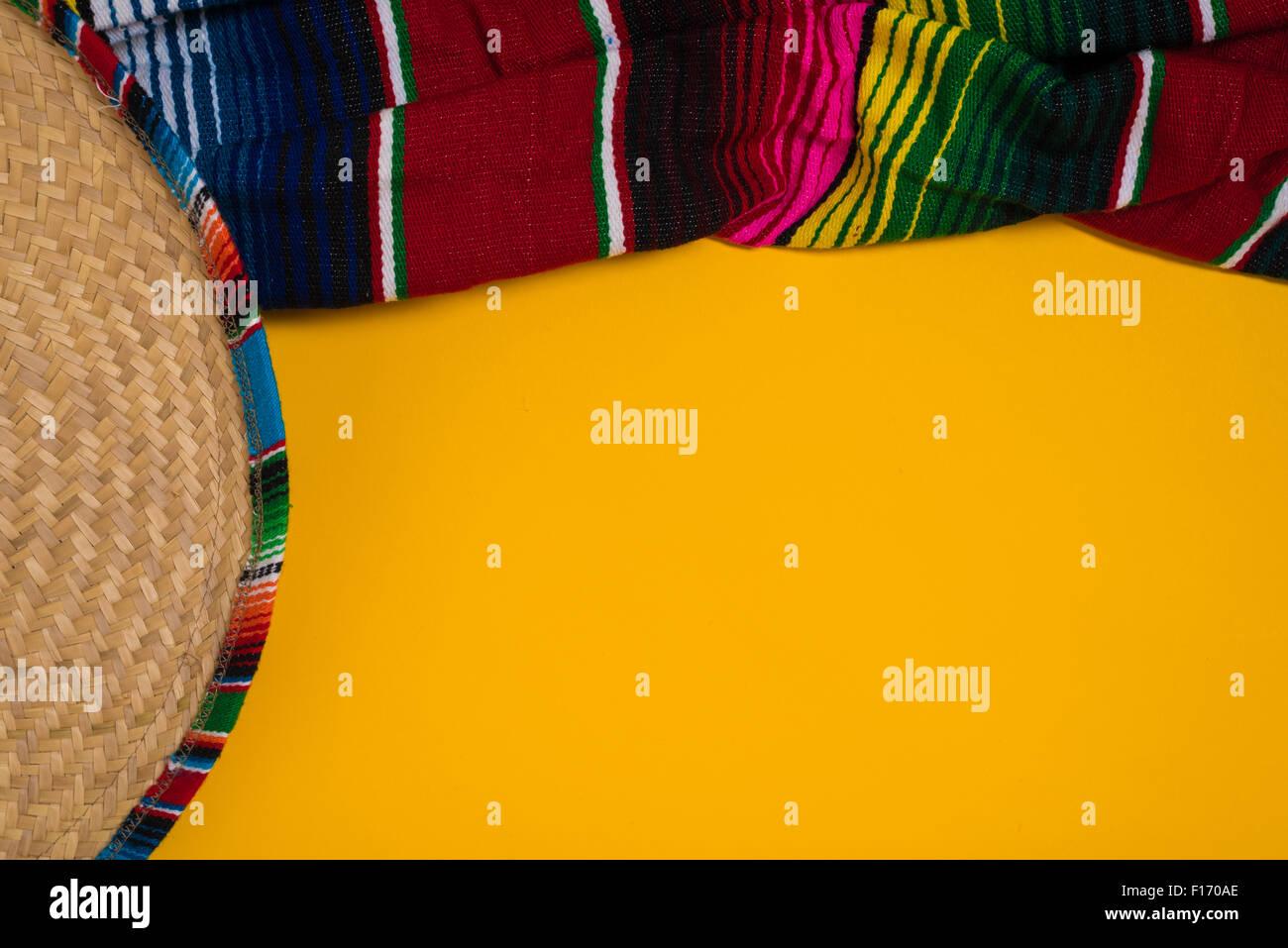 A traditional Mexican Sombrero and serape blanket on a yellow background with copy space Stock Photo