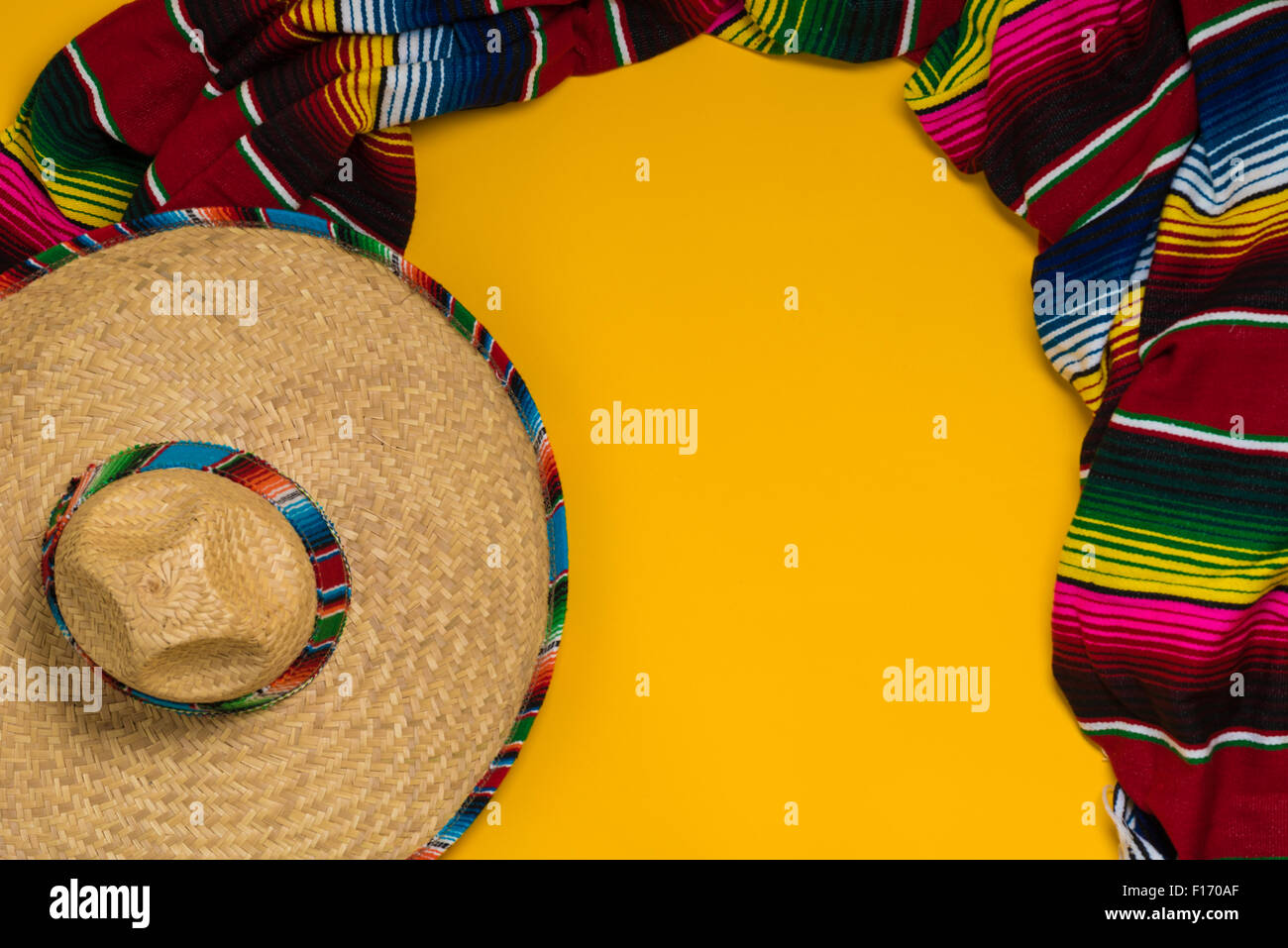 A traditional Mexican Sombrero and serape blanket on a yellow background with copy space Stock Photo