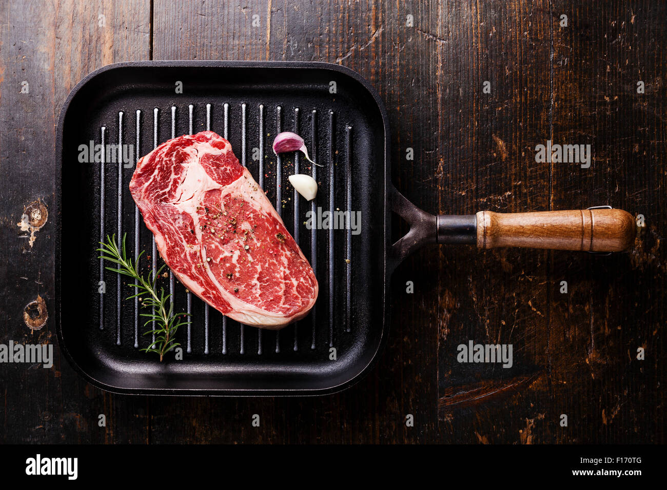 Raw fresh Black Angus Steak ribeye on grill pan on wooden background Stock Photo