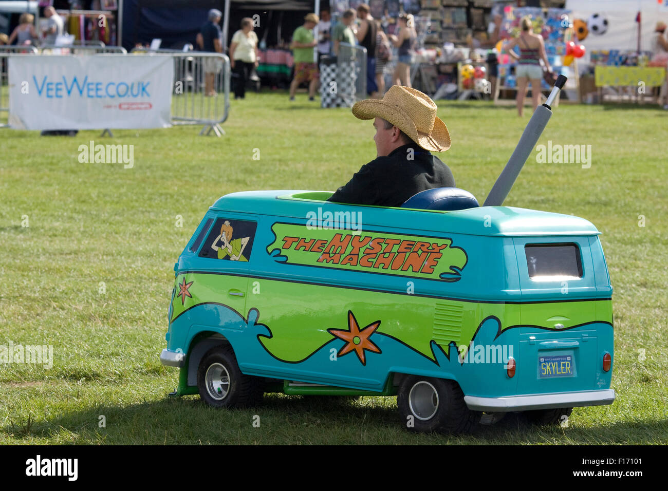 man in a Scooby doo children's peddle mystery machine Miniature van Stock Photo