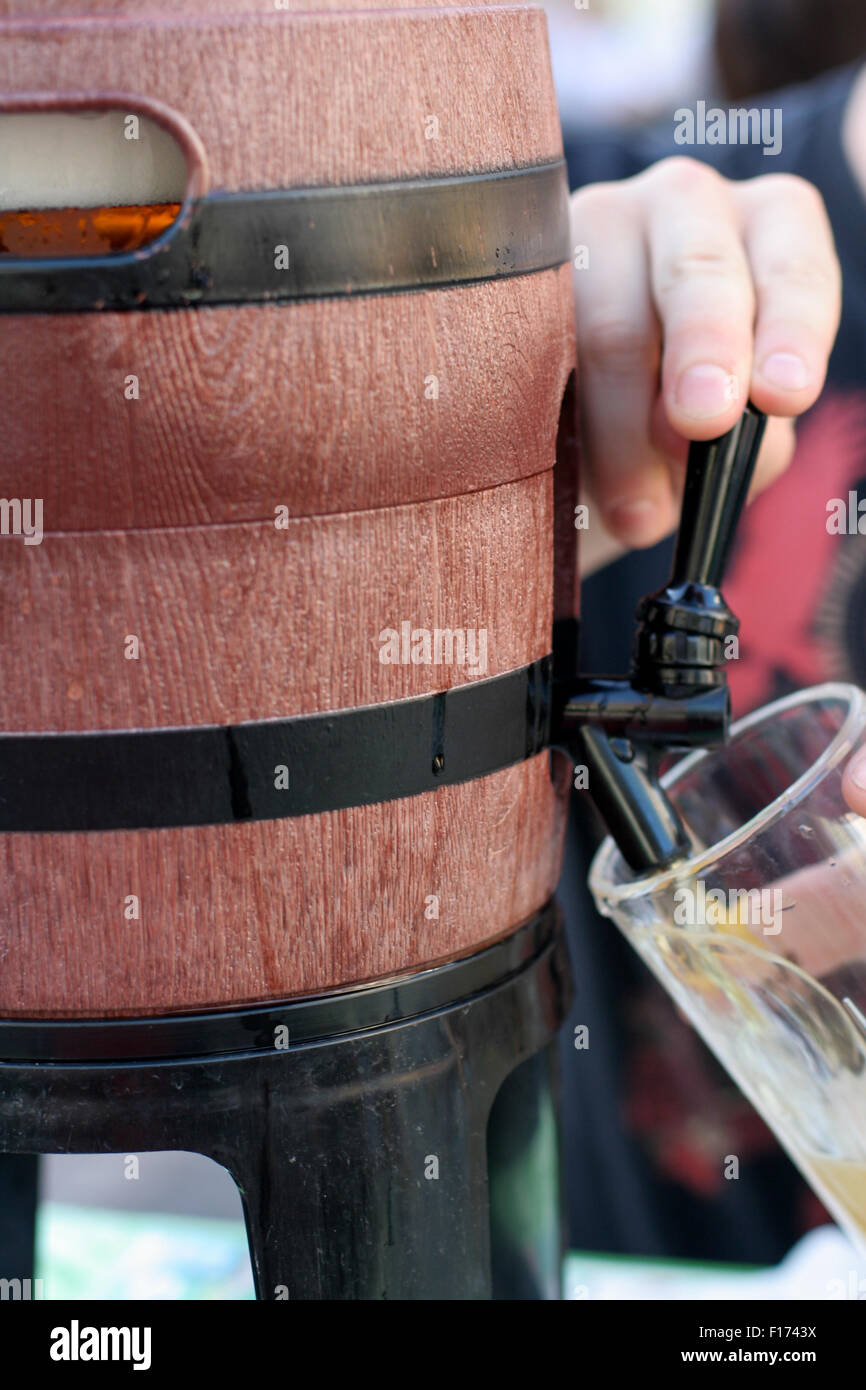 Lager beer with froth foam head getting poured into glass from a keg