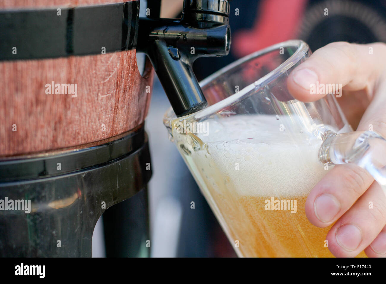 Lager beer with froth foam head getting poured into glass from a keg
