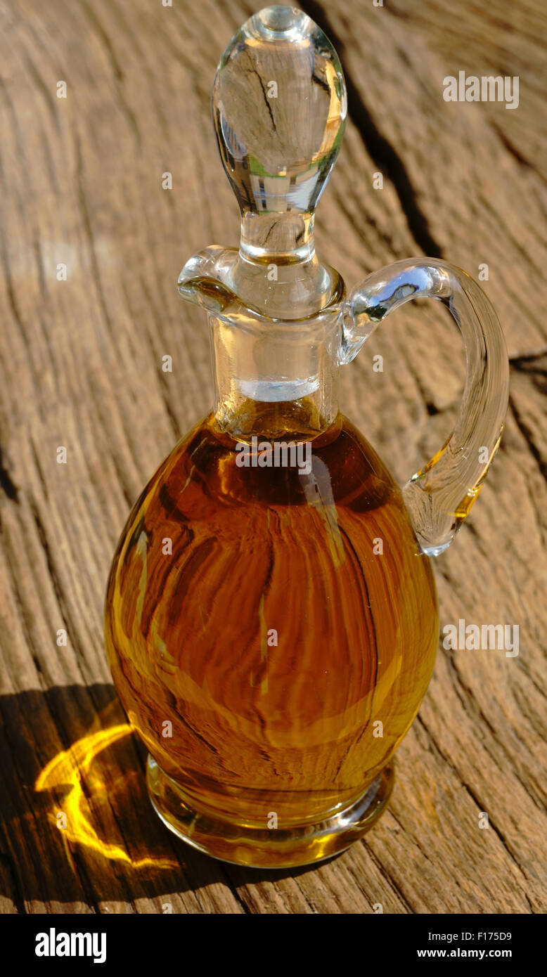 Glass carafe with olive oil on rustic wooden table Stock Photo - Alamy