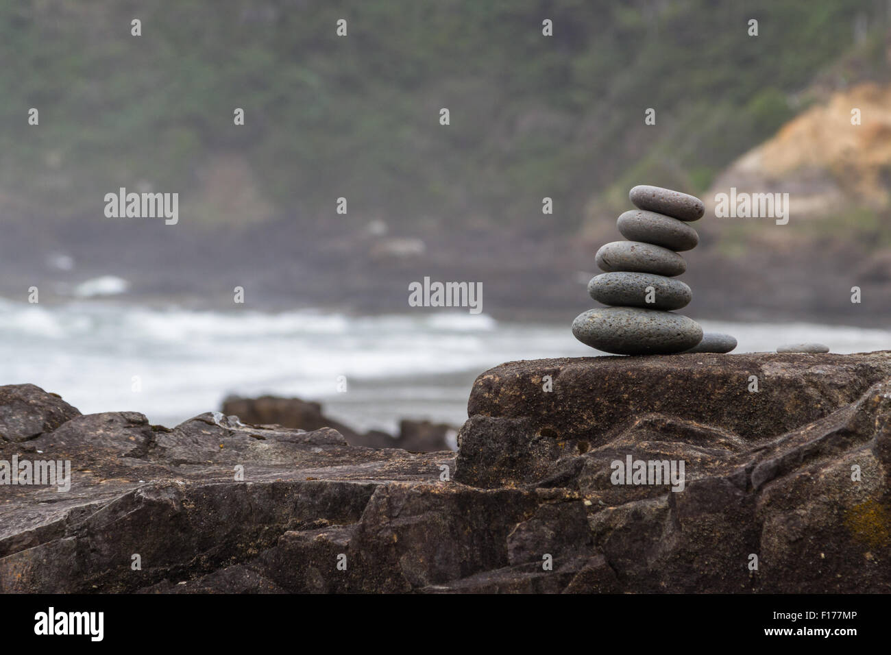 Staked Rocks staked rocks on a natural lava feature with a blurry coastal scene in ...