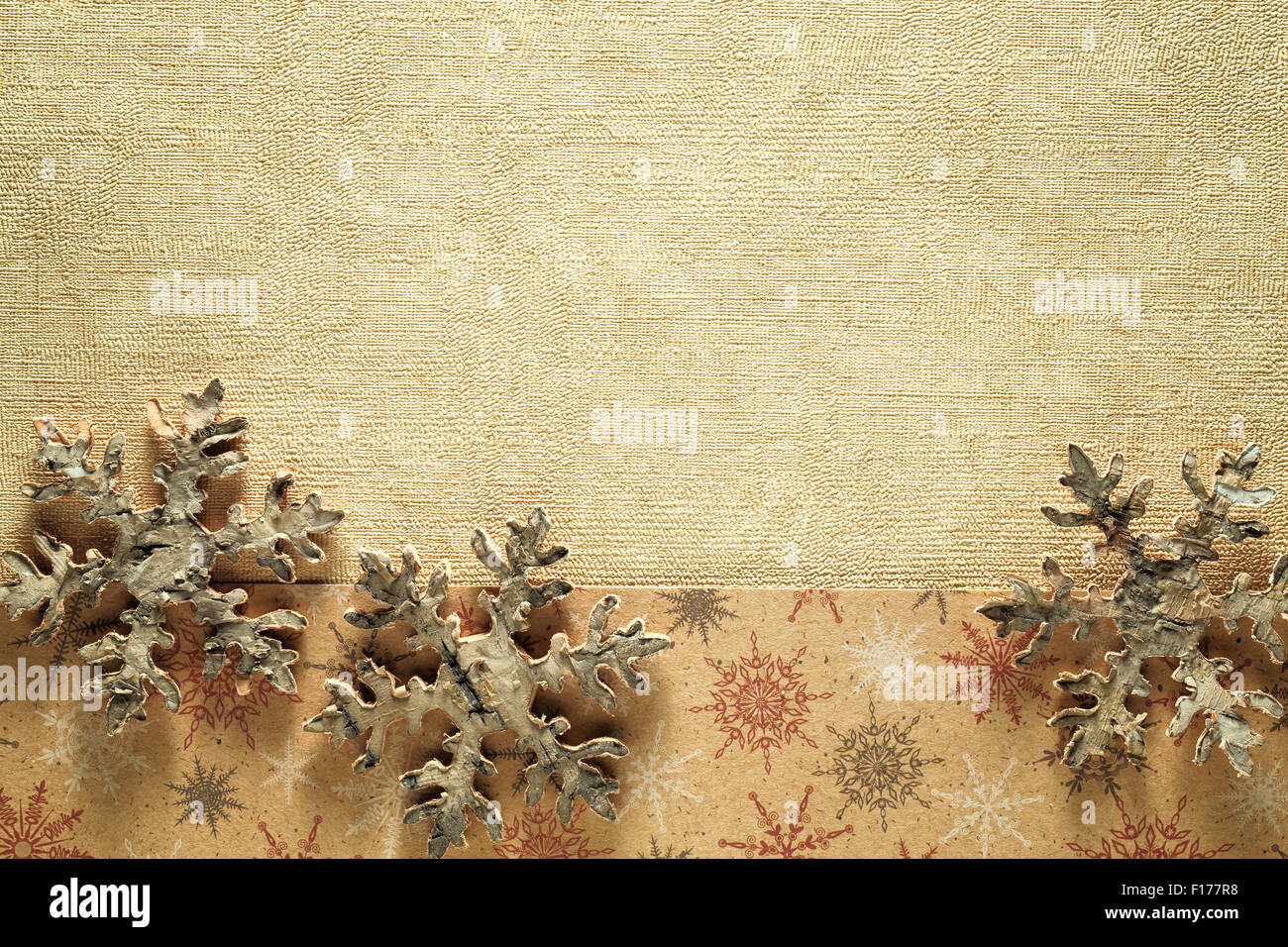 Wooden snowflake on golden paper textured background Stock Photo