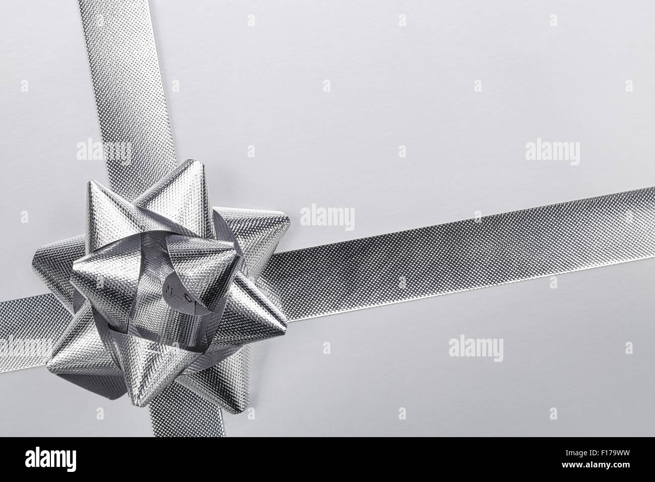 Silver ribbon bow on paper background Stock Photo