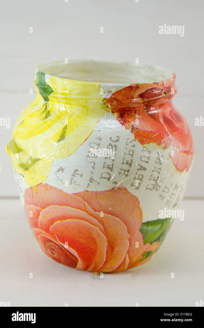 Decoupage decorated flower pattern jar on natural wooden background Stock Photo
