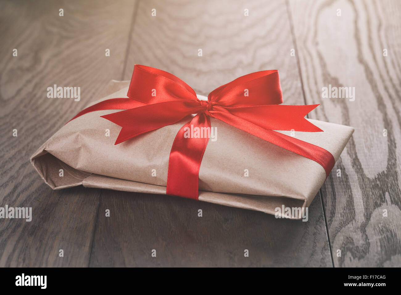rustic present box with red ribbon on wood table Stock Photo