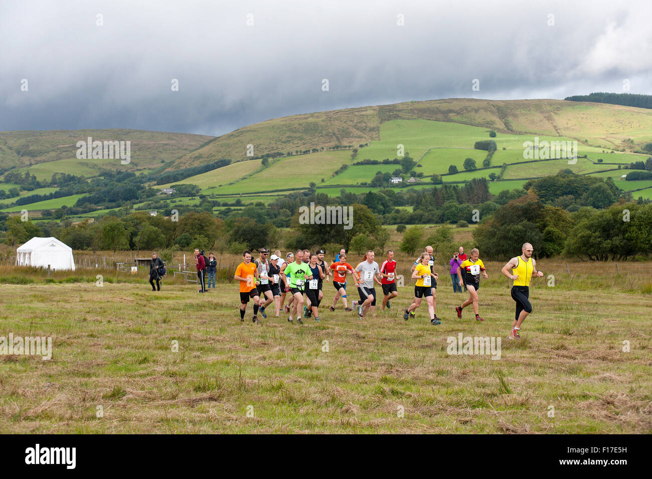 Llanwrtyd Wells, Powys, UK. 29th August, 2015. Participants set off for the Bog Snorkelling Triathalon under rain laden skies on day one of The World Bogsnorkelling Championships which were conceived 30 years ago in a Welsh pub by landlord Gordon Green, and are held every August Bank Holiday at Waen Rhydd Bog near Llanwrtyd Wells. Using unconventional swimming strokes, participants swim two lengths of a 55 metre trench cut through a peat bog wearing snorkel and flippers. The 2014 World Champion is 33 year old Kirsty Johnson from Lightwater, Surrey. Credit:  Graham M. Lawrence/Alamy Live News Stock Photo