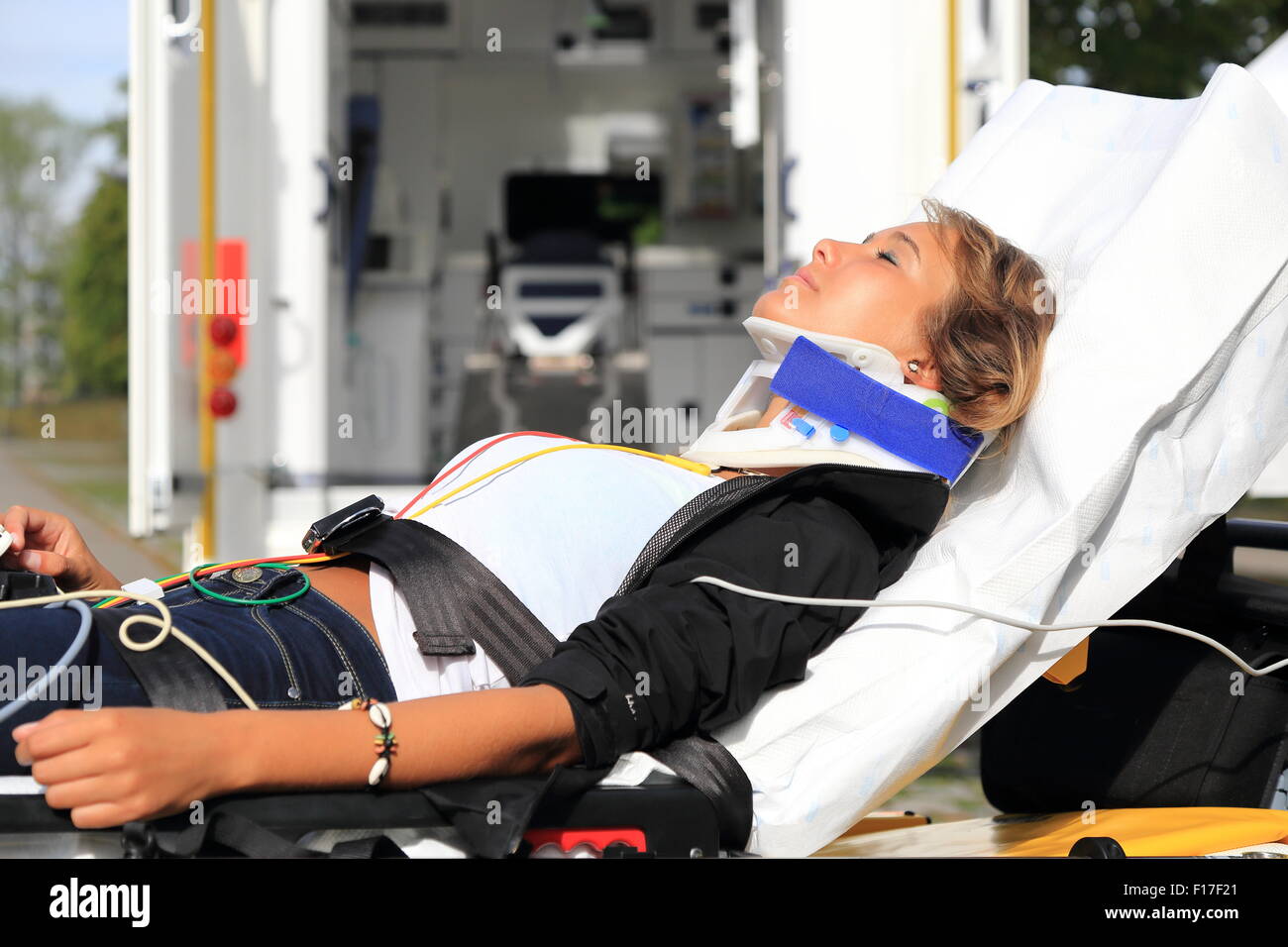 A Woman on stretcher and stifneck before Ambulance car after accident Stock Photo